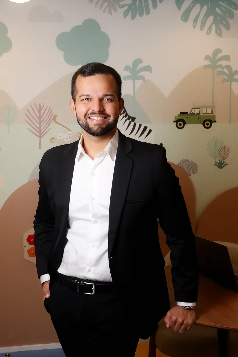 Dr. Bruno William Lopes de Almeida, alergista e imunologista pediátrico, sorrindo no consultório infantil